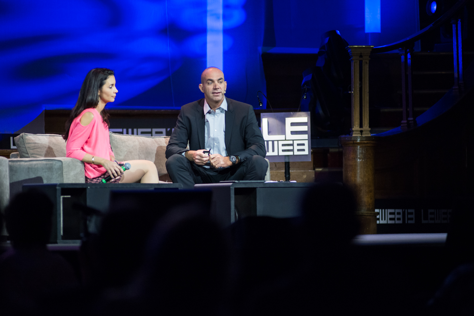 a man and woman are talking on a stage