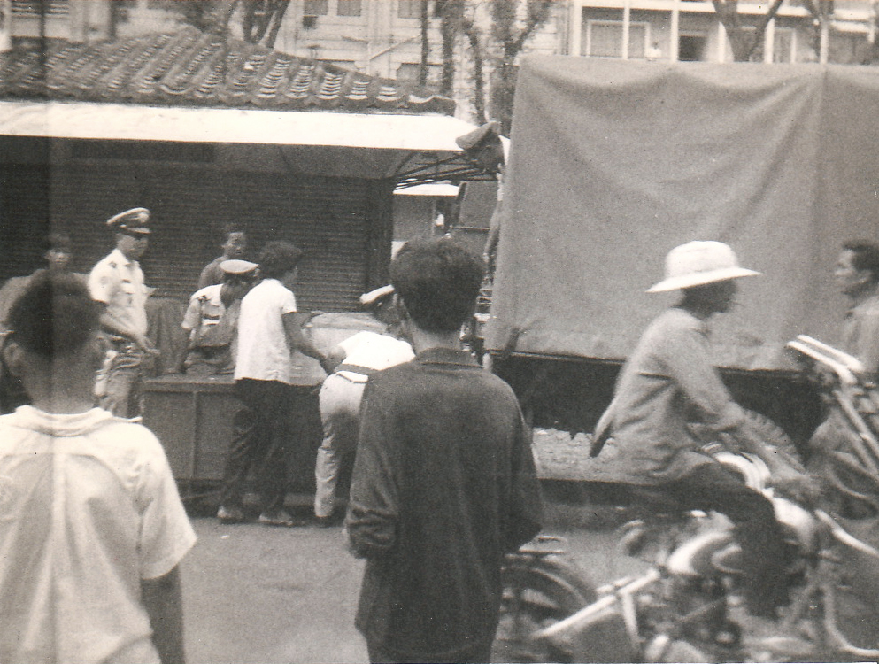 a group of men are gathered on a city street