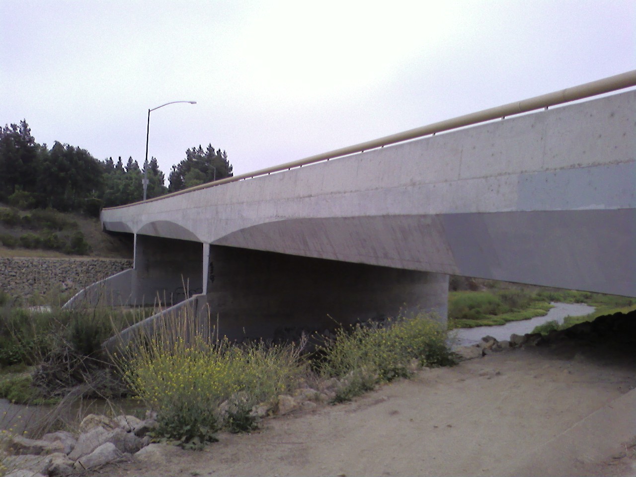 an overpass bridge with a stream running underneath it