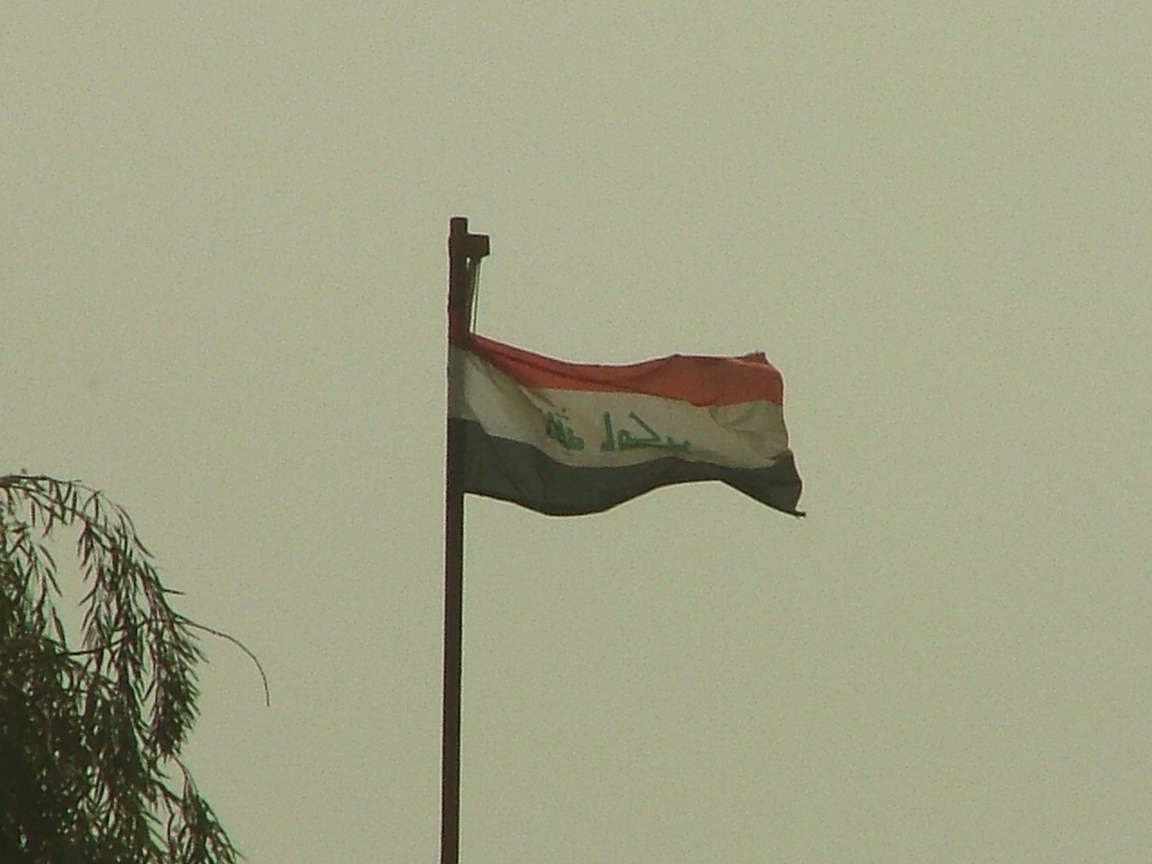 a flag flying in the wind on top of a building