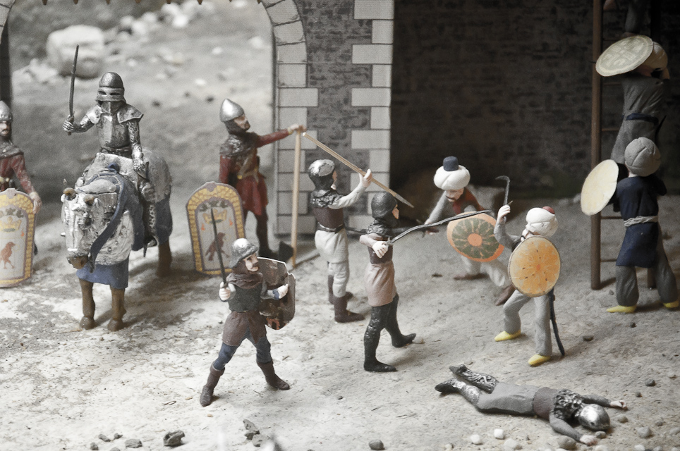 several figurines of a man and some children, with other toys