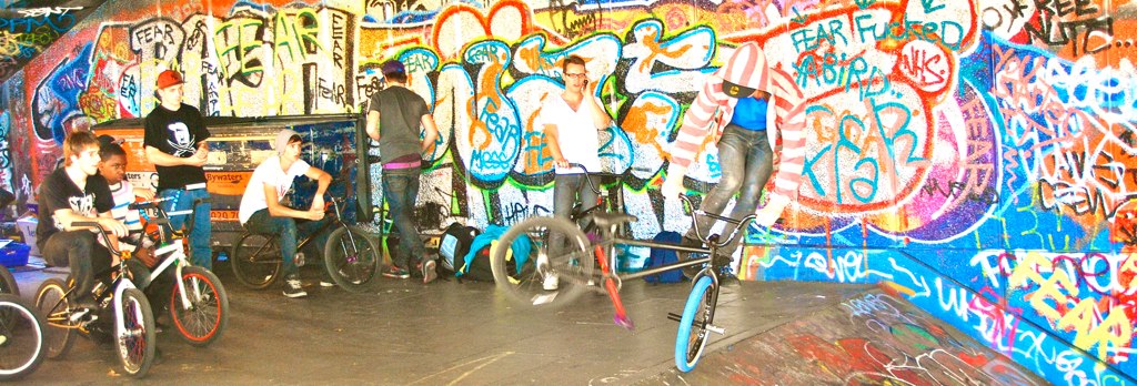 a man on a bicycle riding through a graffiti covered tunnel