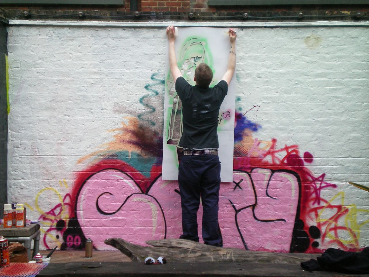 a man is painting on the wall with spray paint