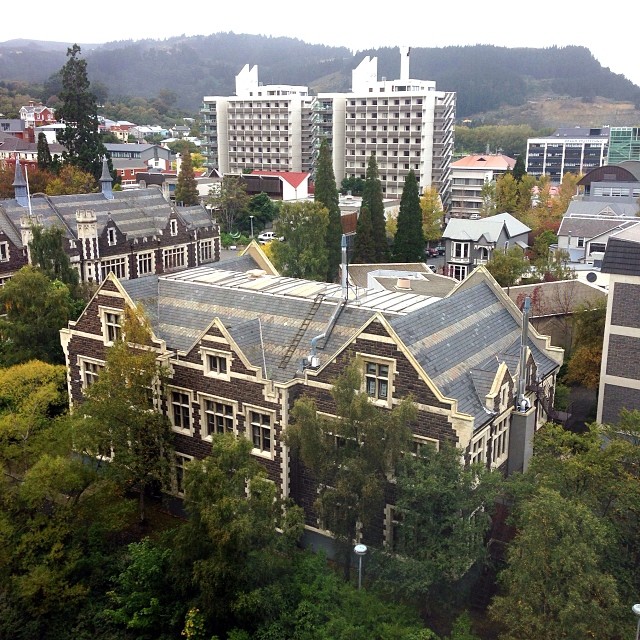 a large building next to many trees and buildings