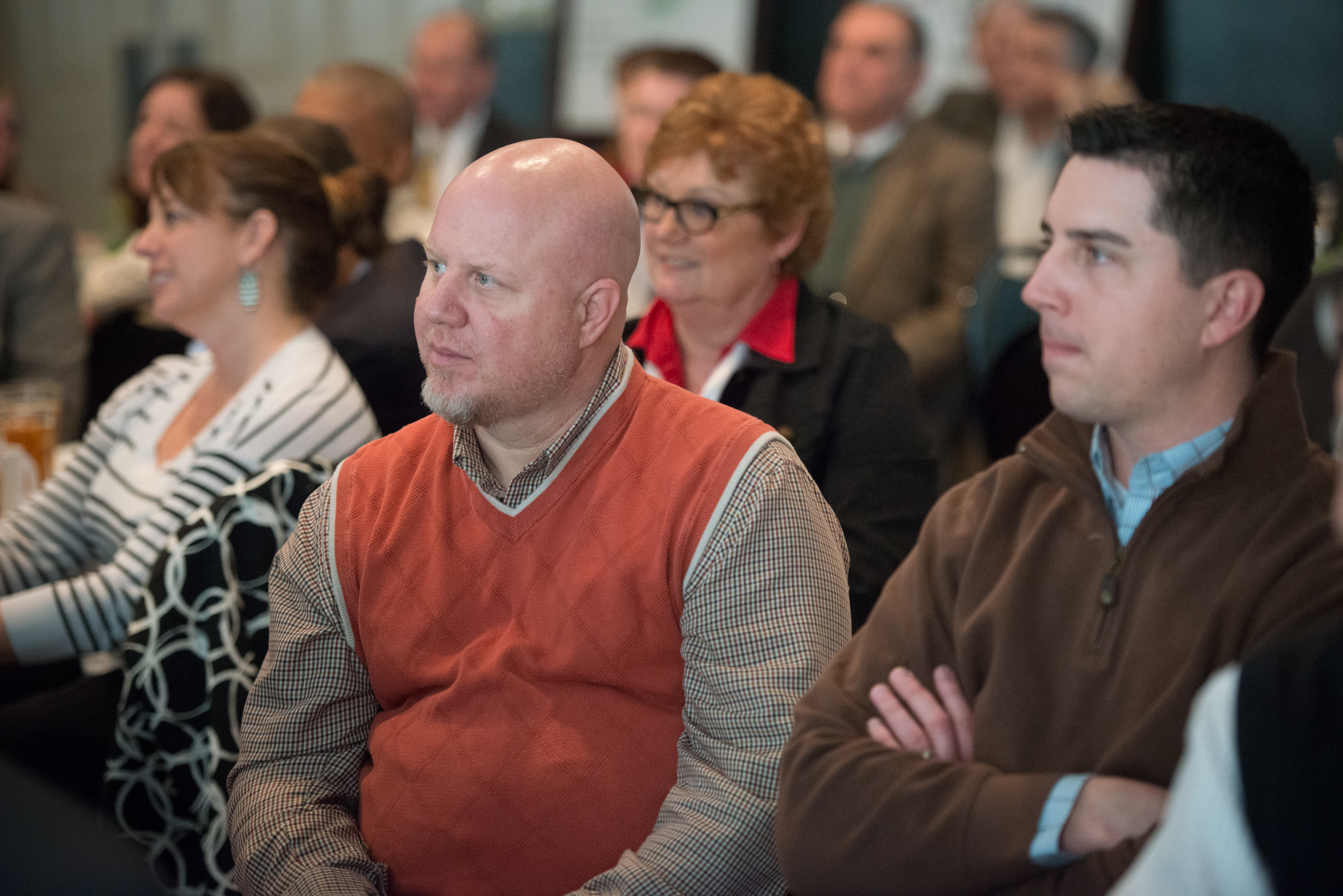 a group of people seated at a conference in a room