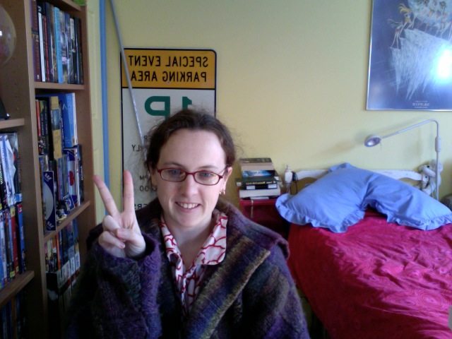 woman in her room giving the peace sign