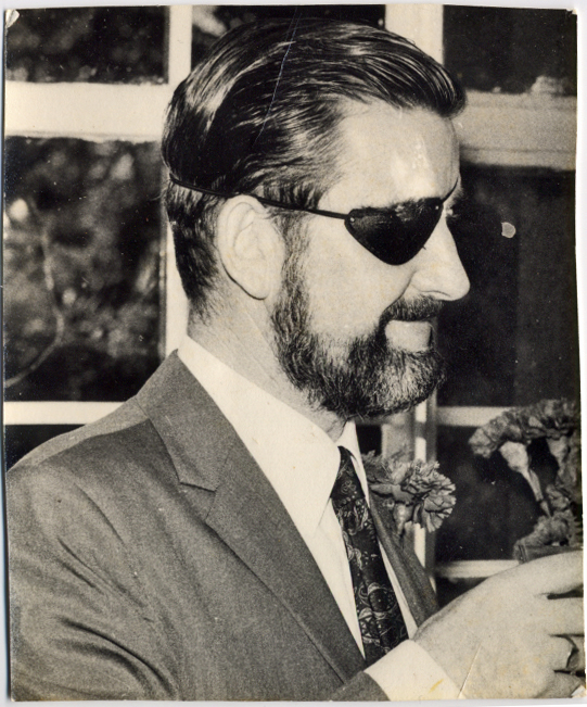 a man wearing sun glasses holds a pipe