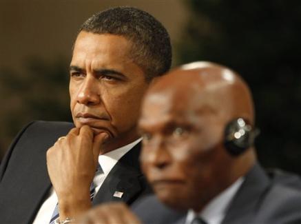 the president and another african american man in a suit sit next to each other