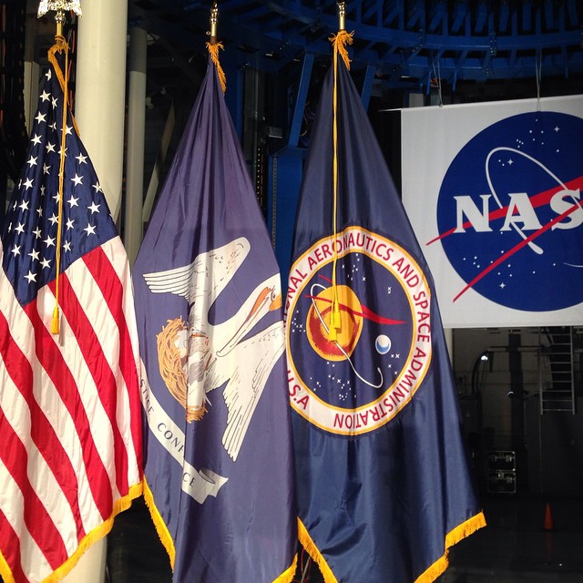 flags of nasa and american flag hanging from a ceiling