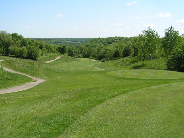 a large open golf course on the side of a hill