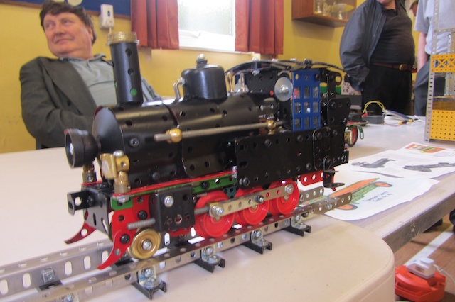 this is an image of a man and woman looking at a miniature locomotive