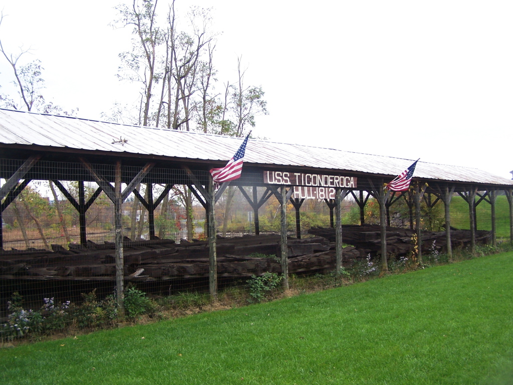 a covered area with several rails sitting in the grass