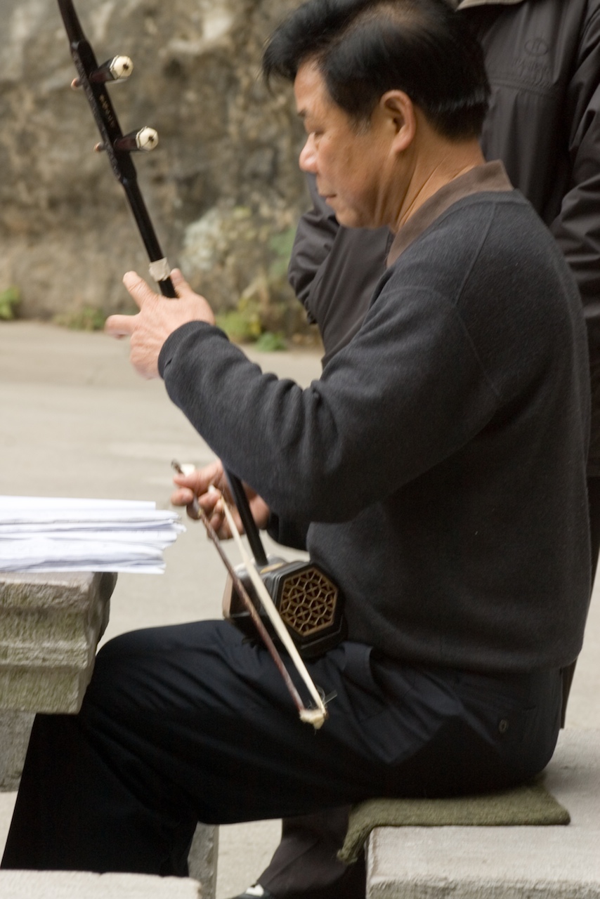 a man is sitting and holding a sword