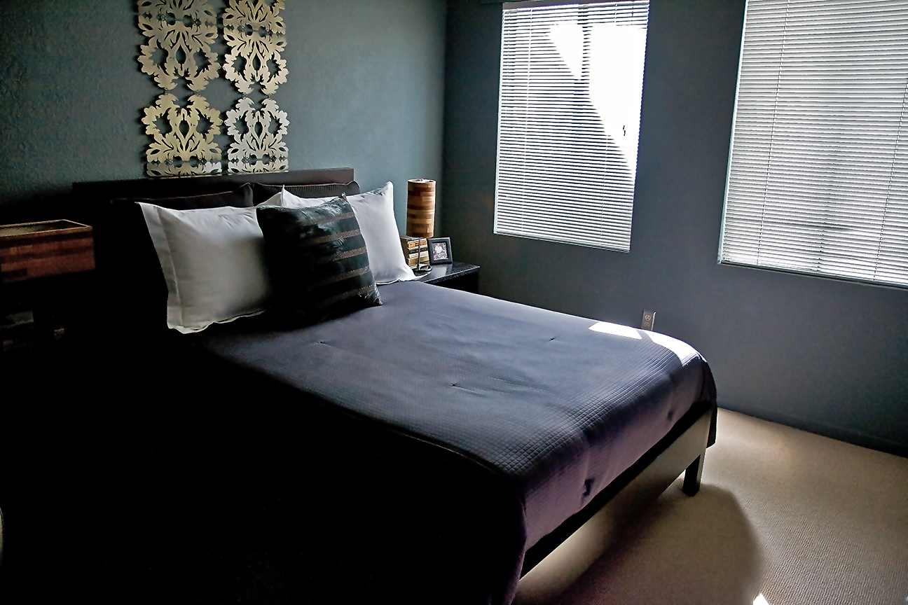 dark room with gray bed and art on the wall