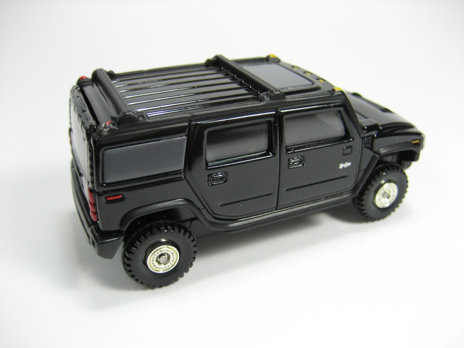 a black toy truck with three doors and three tires