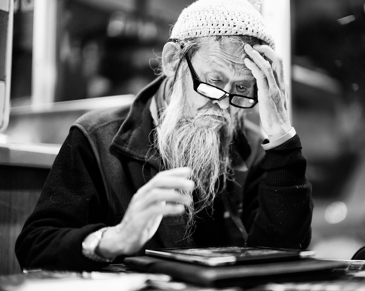 a man with a beard and glasses sits at a table