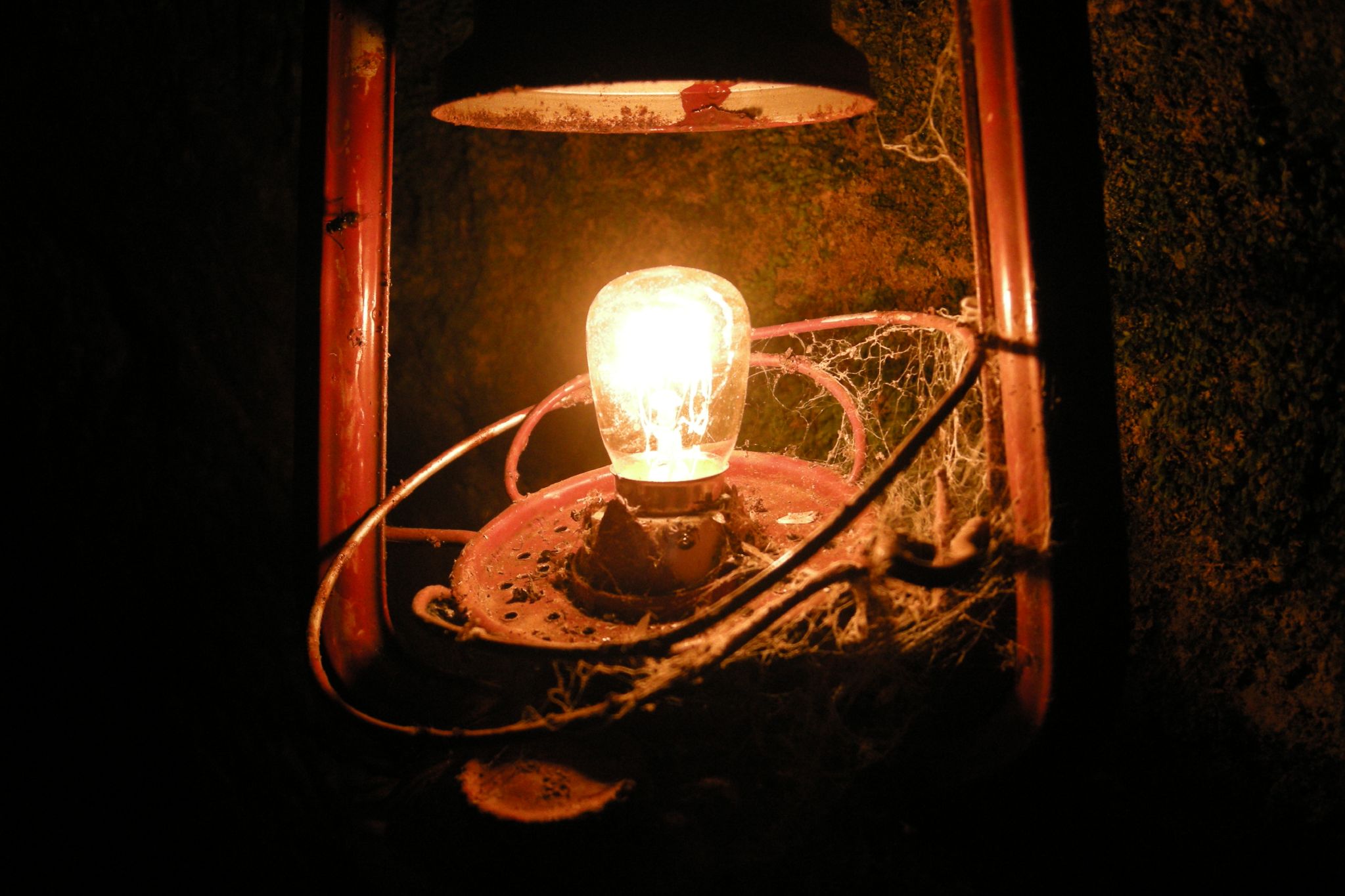 a very old light is glowing from a bulb on a broken lamp post