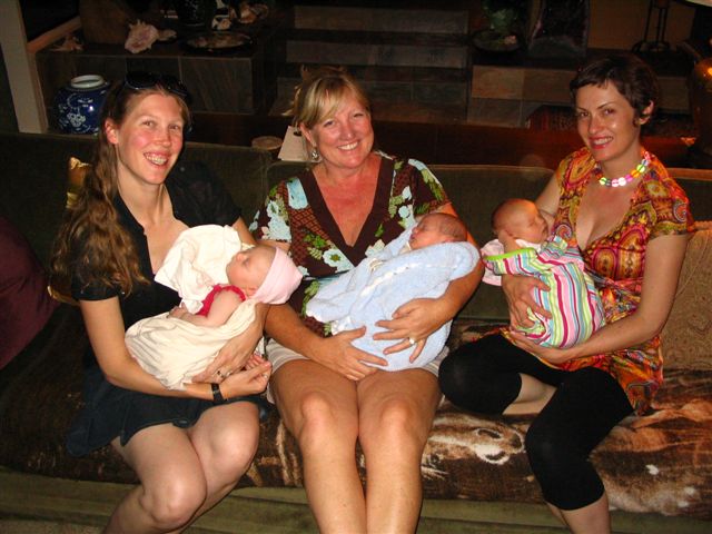 two women are sitting on the couch with baby