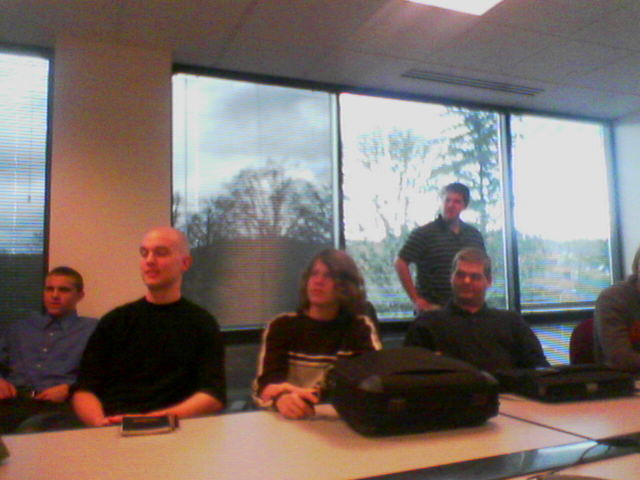 a group of people are sitting at an office desk