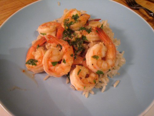 a plate filled with shrimp, rice and green onions