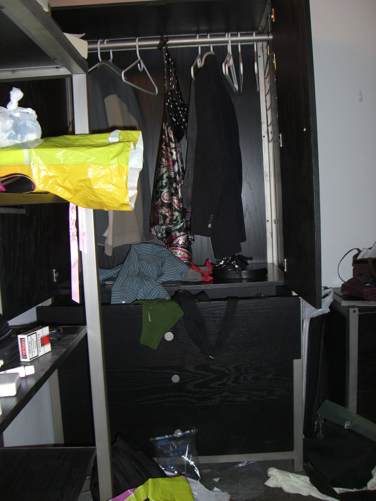 a closet with several clothes hanging off shelves and clothes hanging from racks