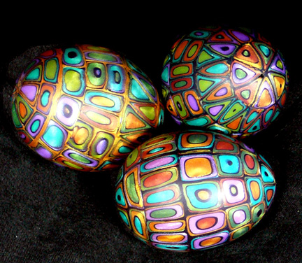 four decorated easter eggs laying on black paper