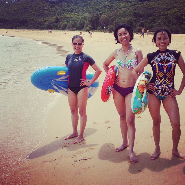 three people on the beach with two surfboards and one with a body board