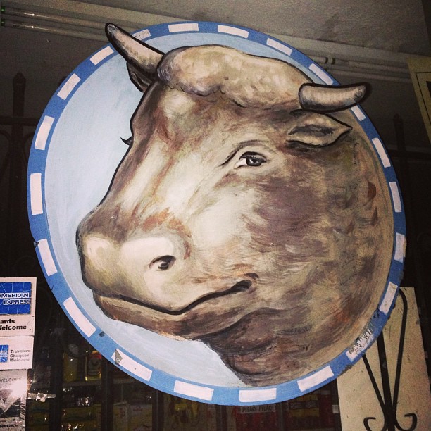 a painted picture of a cow on a round blue plate