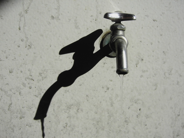 a faucet has been casting long shadows on the wall