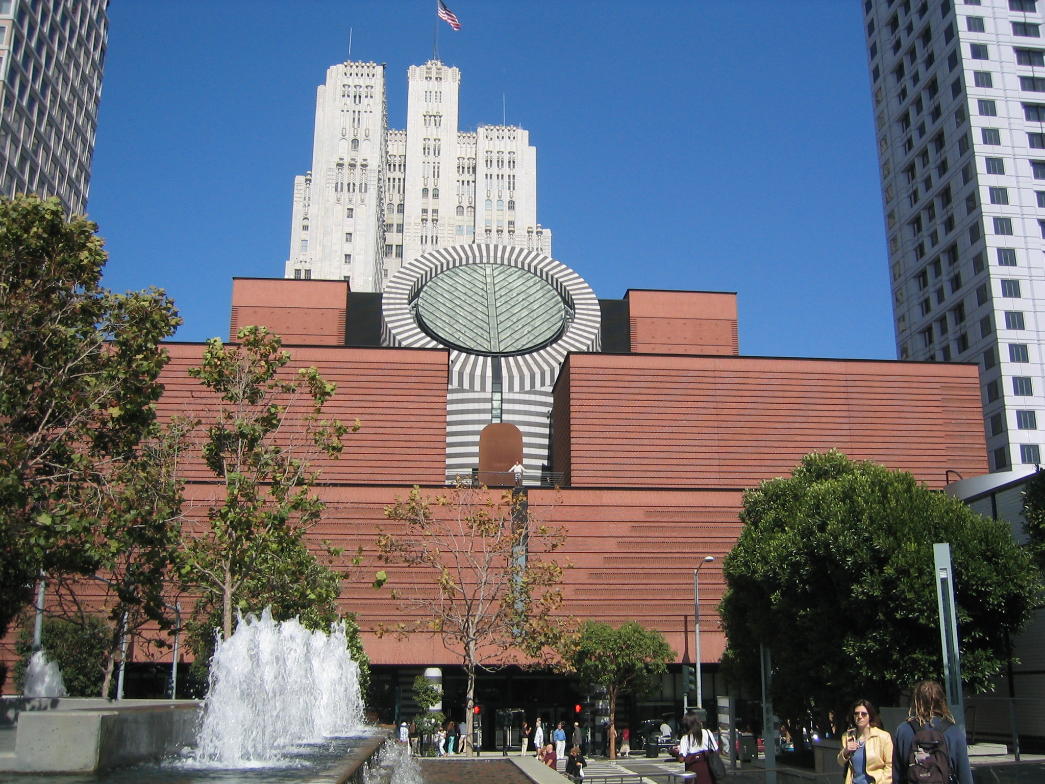 a building with a giant clock with the city's skyline in the background