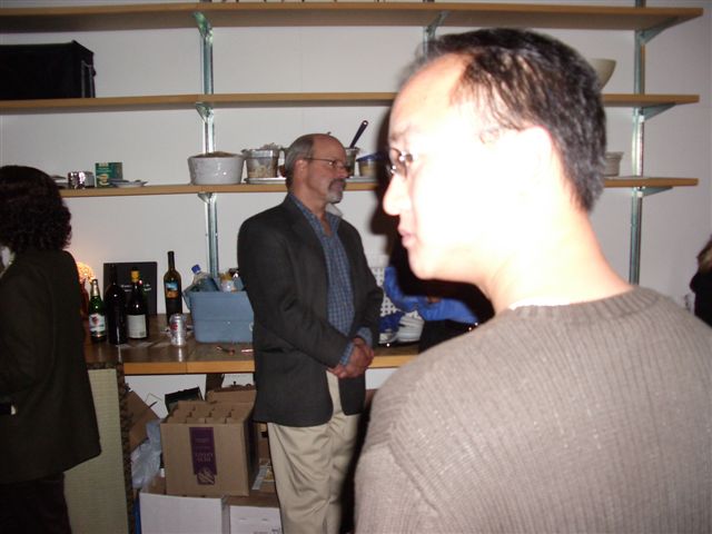 man standing in room full of people with shelves