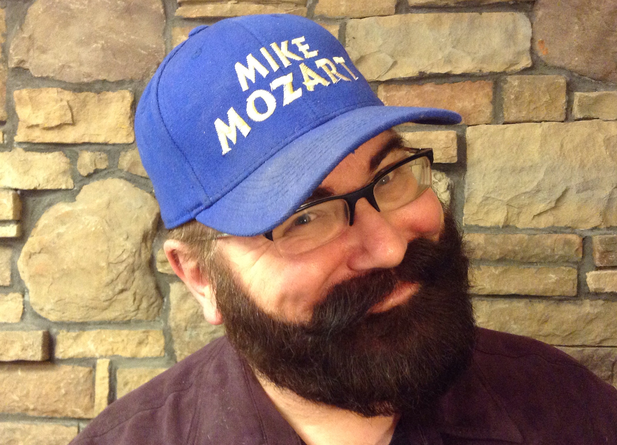 a man with a beard wearing a hat and glasses