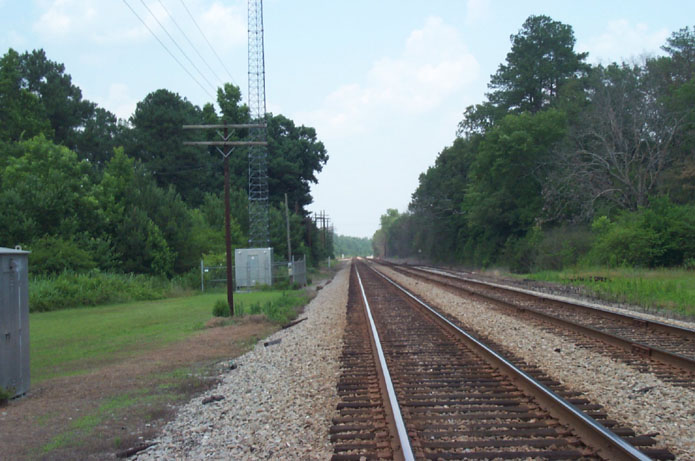railroad tracks next to a grassy area