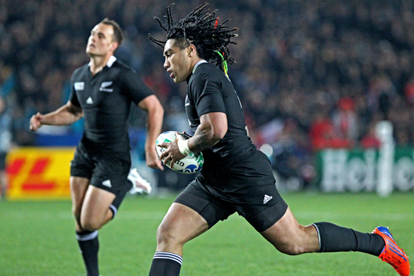 a man in a black jersey is running with a rugby ball