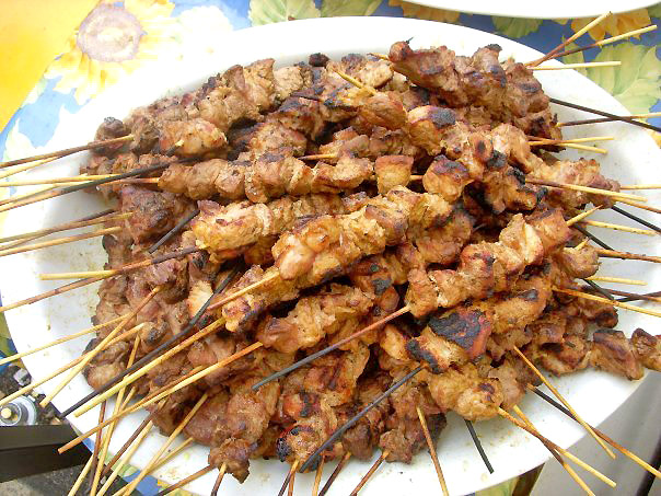 several skewers of food on a plate and placed on a table