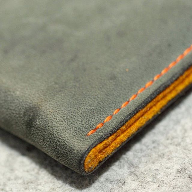 an orange stitch on a gray wallet