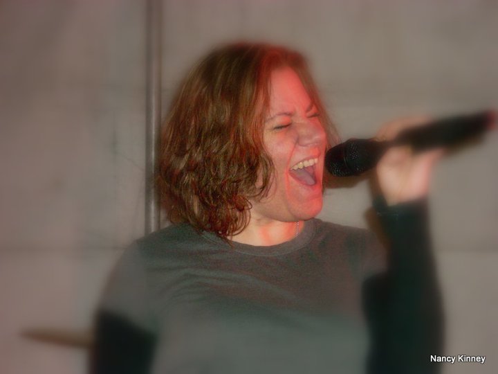 a woman holding a microphone up to her mouth