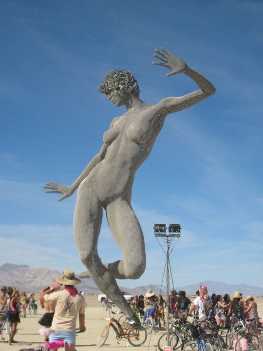the woman statue has arms spread in the air and  out