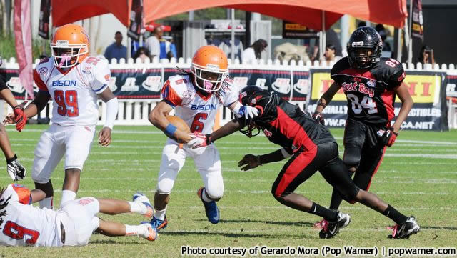 football players running with a ball on the field