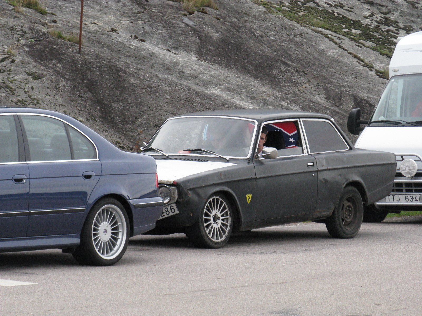 two vehicles sitting side by side in front of some rocks