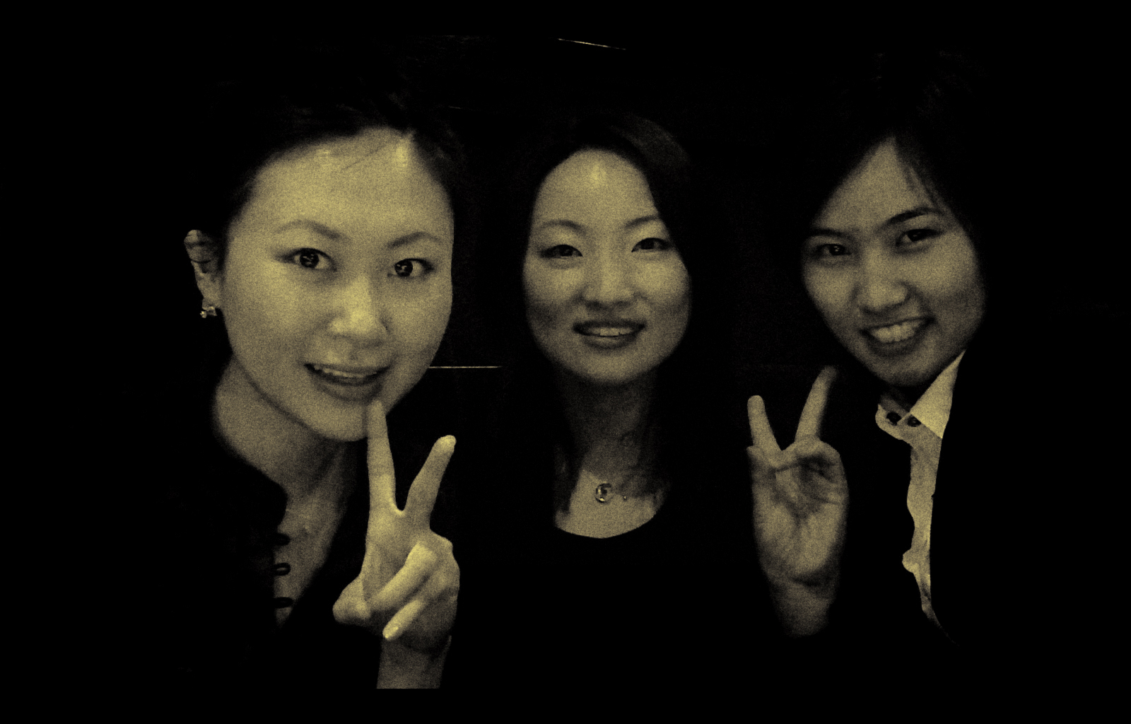 three young ladies giving the peace sign with their fingers