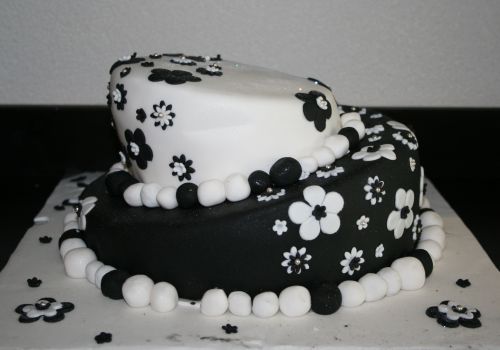 two layer cake with white, black and white icing and floral decoration