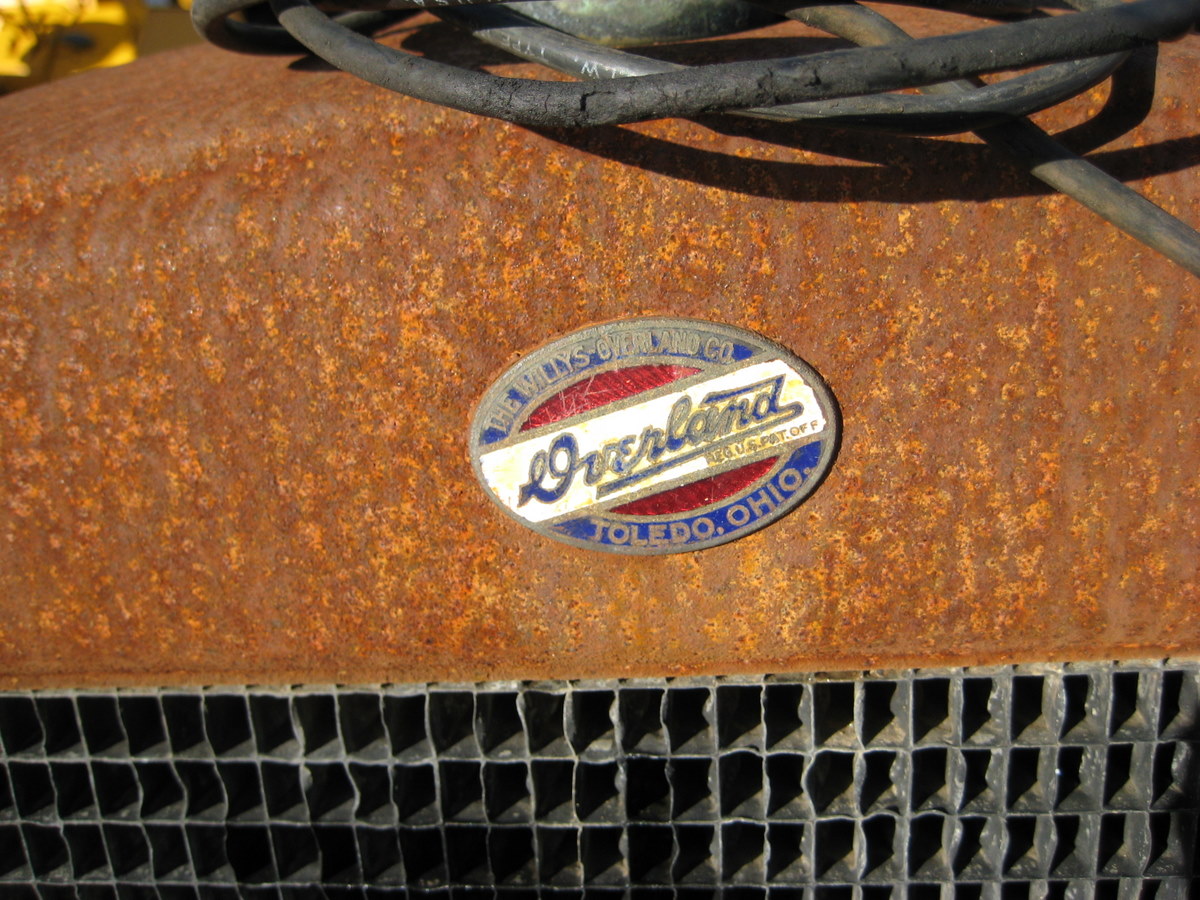 the emblem of an old truck with rusty rust on it