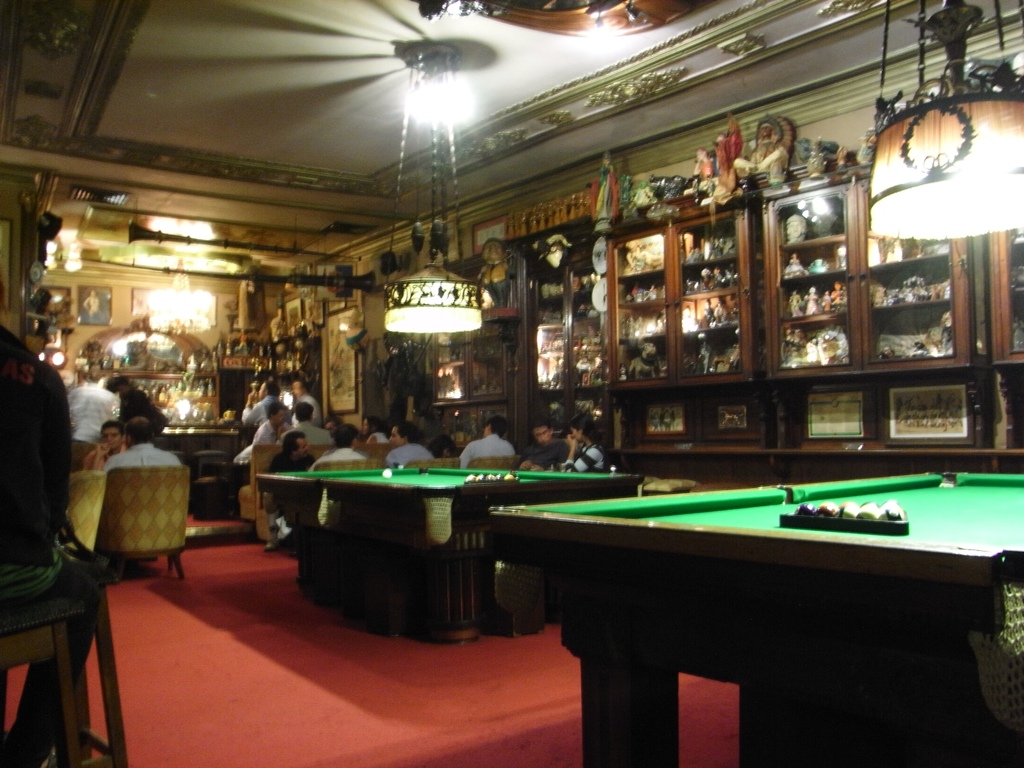 some green pool tables and people in the room
