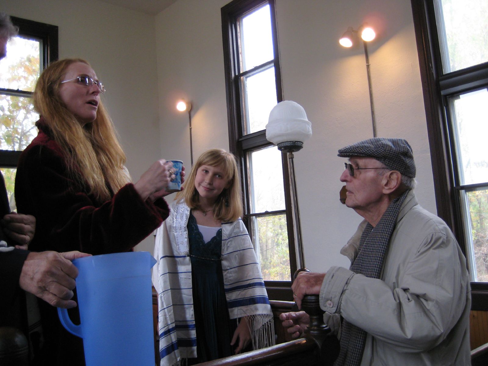 three people are standing in the room with one talking