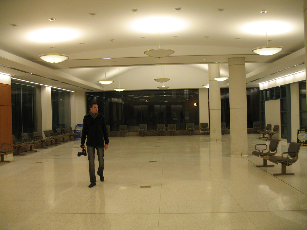 a man walking in an empty large room with no one