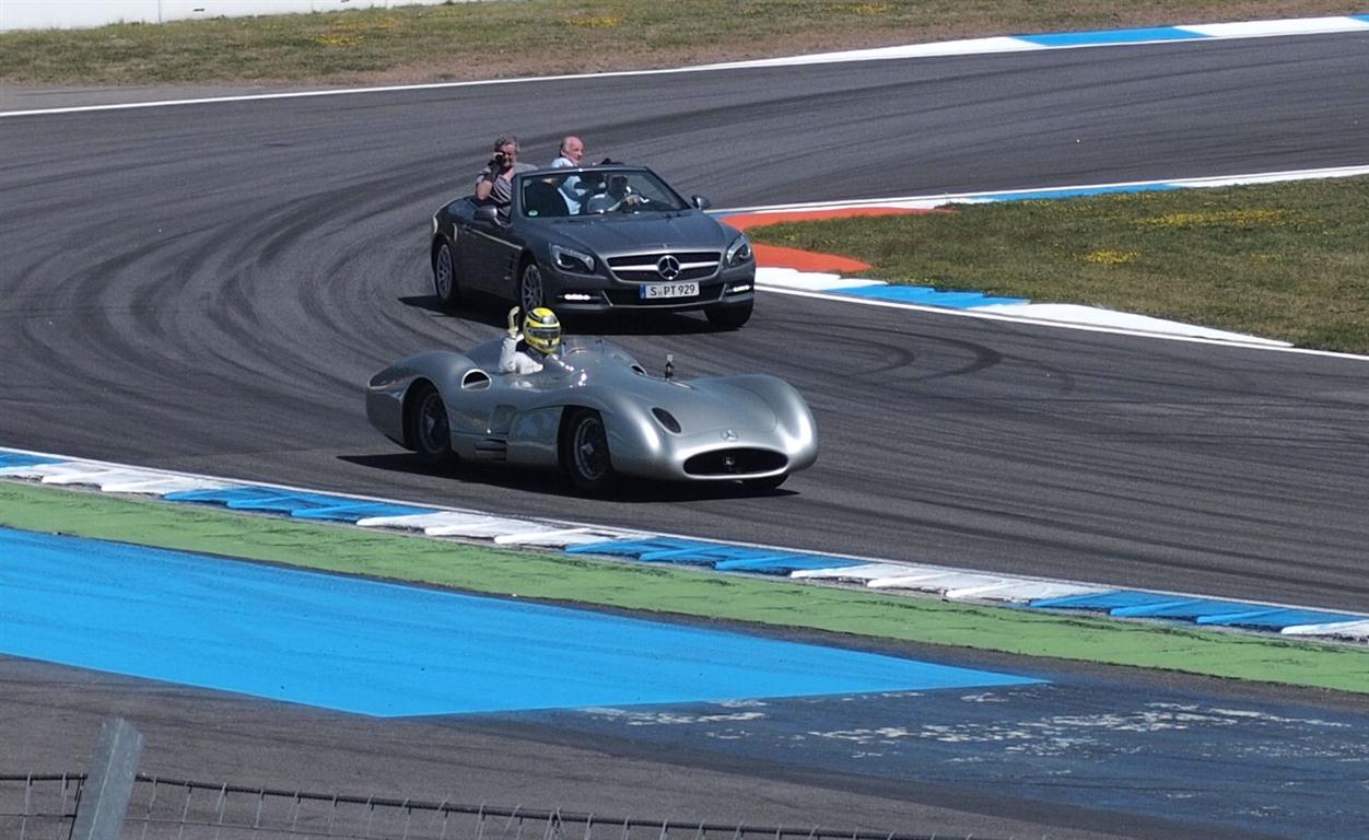 a car driving down a race track with a person sitting in the car