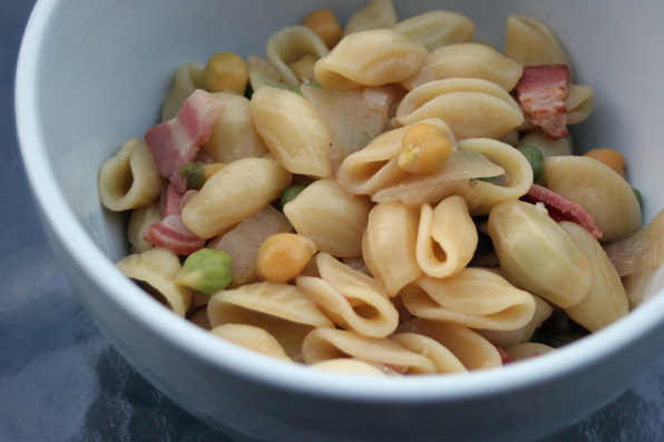 close up view of a bowl full of pasta, ham and vegetables