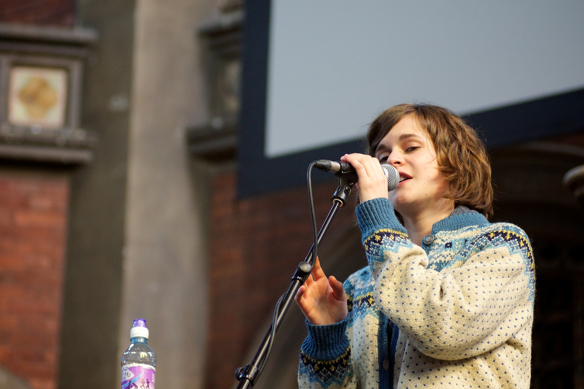 a person standing up singing into a microphone