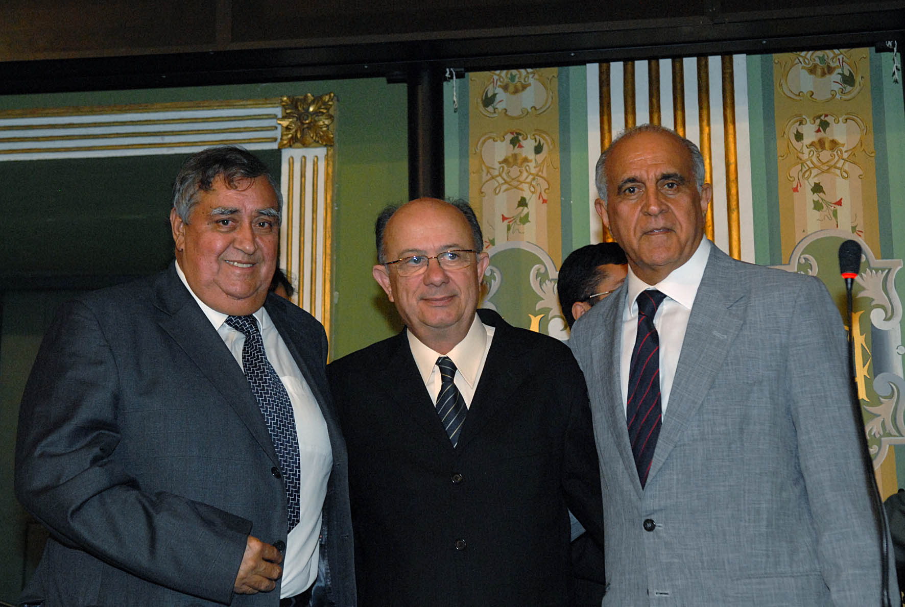 three gentlemen are smiling in suits and ties